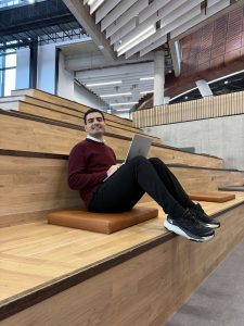 A man sitting on a bench with a laptop