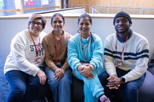 Group of friends sit together inside a university building.